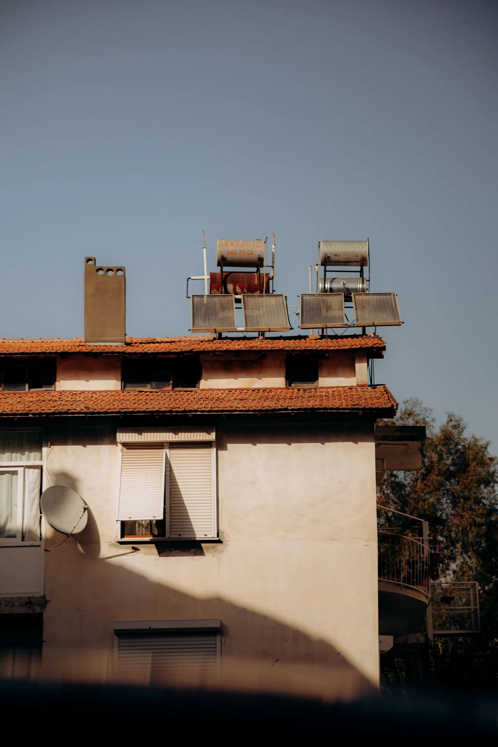 Solar water heaters on a tiled roof in the Mediterranean sun